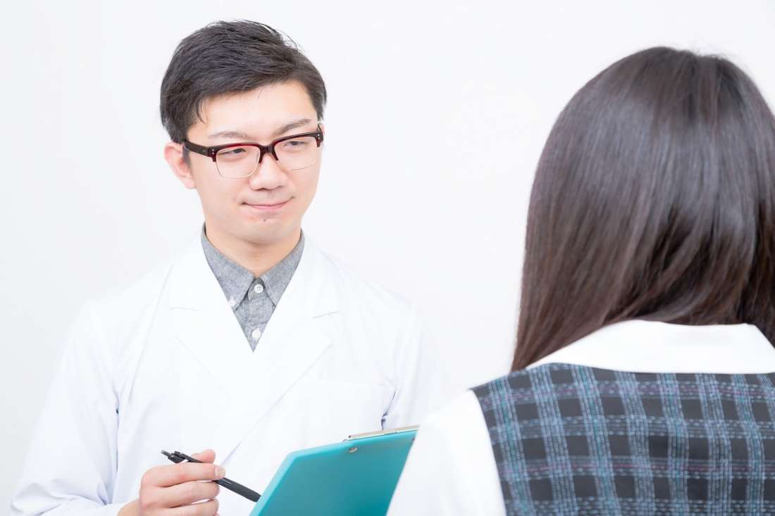 医師が女性の話を聞いている様子