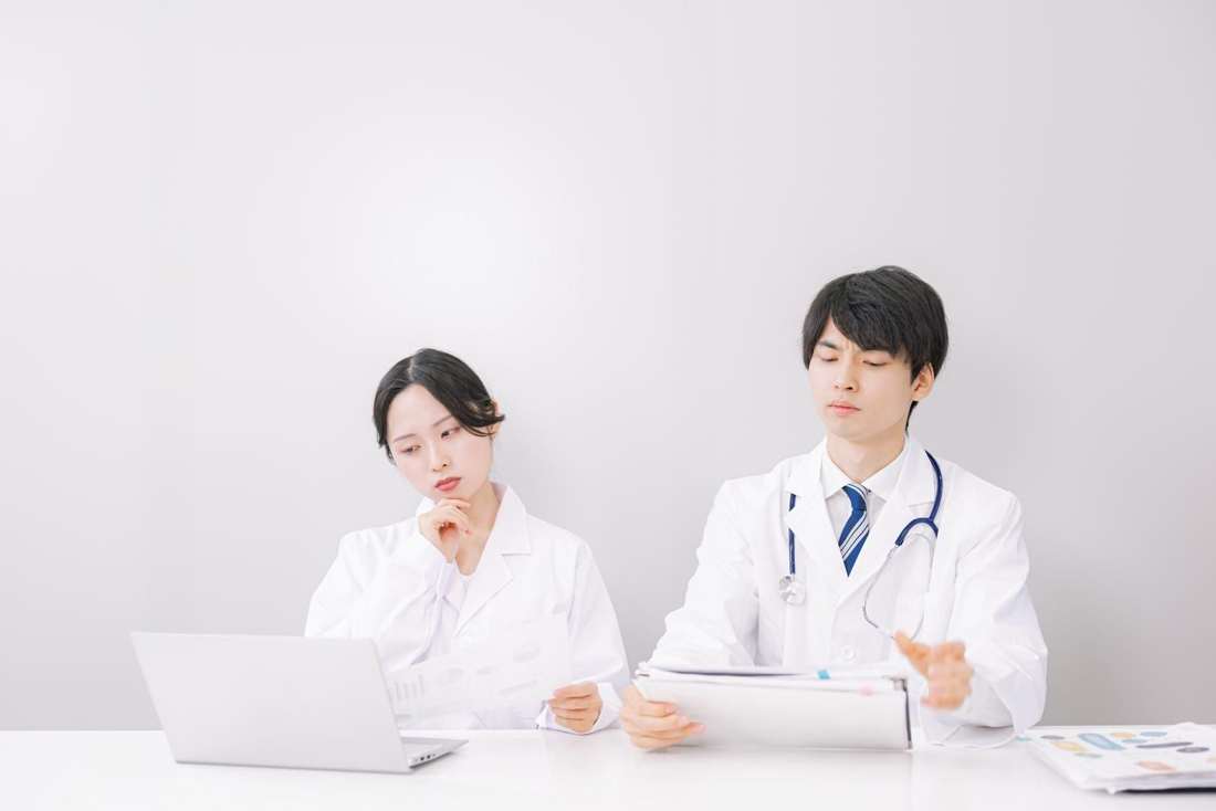 パソコンの前で話し合う医師たち