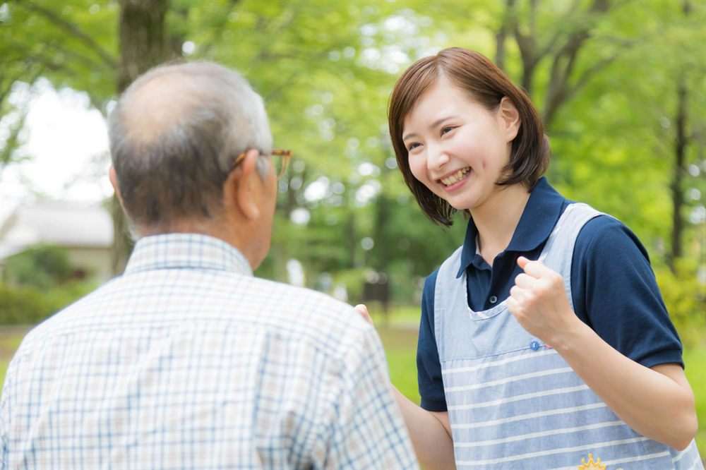 公園で男性と笑い合うスタッフ