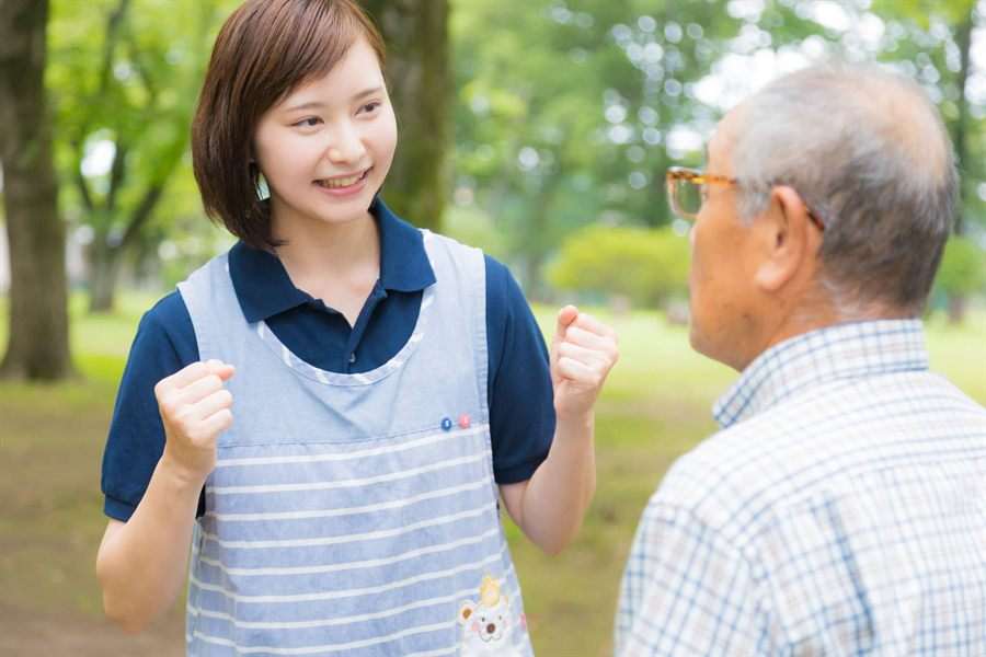 公園で男性を笑顔で励ますスタッフ