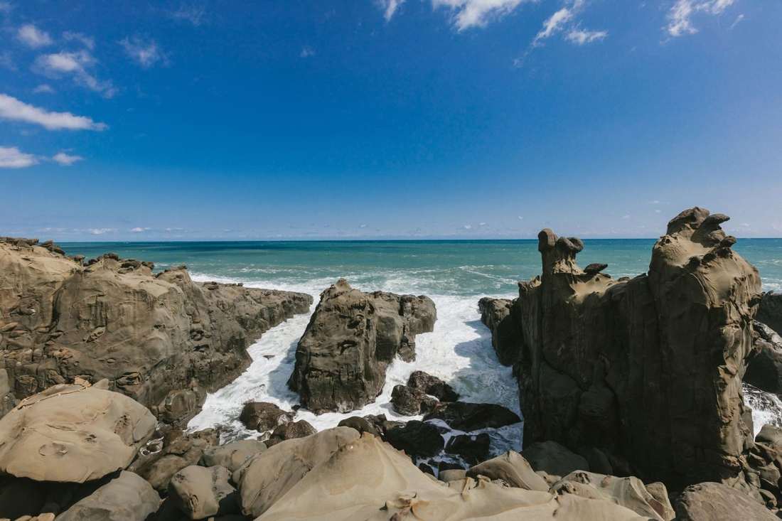 岩に波が打ち寄せる海岸と青空