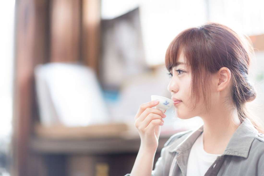 試飲用の杯で香りを確かめる女性