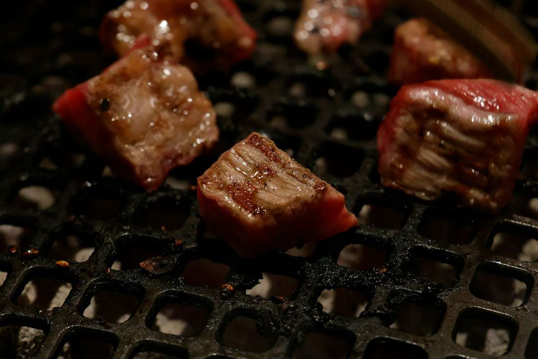 炭火の網で焼かれる和牛